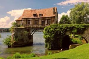 een huis op een brug over een rivier bij Maison face au moulin Giverny in Vernon