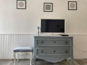 een tv op een dressoir met een kruk bij Maison face au moulin Giverny in Vernon