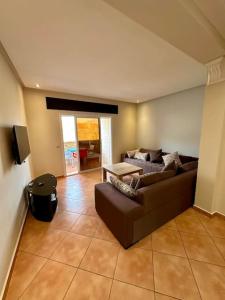 un soggiorno con un divano e un tavolo di Apartamentos Al Borj 4J إقامة البرج a Ifargane