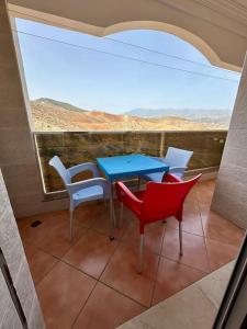 un tavolo e sedie su un balcone con vista di Apartamentos Al Borj 4J إقامة البرج a Ifargane
