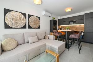 a living room with a couch and a kitchen at Smash A - Apartments with Private Pool in Novalja