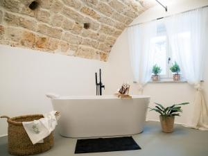 e bagno con vasca e parete in pietra. di Palazzo Santa Ninfa - Luxury Mansion a Palermo Altre 38 foto