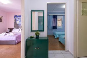 a bedroom with a bed and a green dresser and a mirror at Rastoni - Beach Family House in Chorafakia