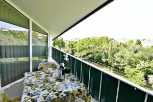 ein Tisch auf einem Balkon mit Blick auf Bäume in der Unterkunft Beleuchtete Wohnung Eva in Zambratija, Savudrija, nahe dem Strand, mit Balkon mit Meerblick, Klimaan in Savudrija