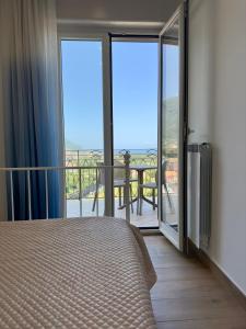 a bedroom with a bed and a balcony with sliding glass doors at Blue House GM in Gragnano