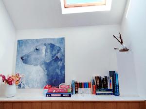 a painting of a dog on a shelf with books at Willa AL-BA in Łeba
