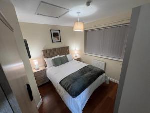 a bedroom with a bed and two lamps and a window at Big new house! 5BDR, sleeps 13, with parking in Carrington