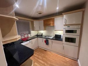 a kitchen with white cabinets and a black counter top at Big new house! 5BDR, sleeps 13, with parking in Carrington