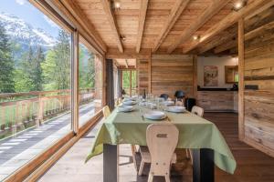 レ・ズッシュにあるChalet 1000のバルコニーにテーブルと椅子が置かれたダイニングルーム