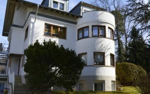 a large white house with windows on the side of it at Schönes Ferienhaus mit Garten in Friedrichshafen am Bodensee in Friedrichshafen