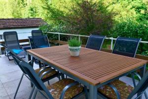a wooden table with chairs and a potted plant on it at Schönes Ferienhaus mit Garten in Friedrichshafen am Bodensee in Friedrichshafen