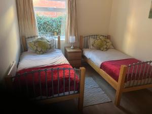 two twin beds in a room with a window at Large Ground floor apartment in the heart of Church Stretton with free parking in Church Stretton