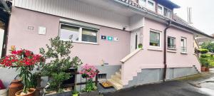 a pink house with stairs on the side of it at Feriendomizil Burgert Nähe Europapark in Kippenheim
