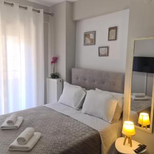 a bedroom with a bed with towels on it at COZY GOLD #DTerra Apartments# FREE PRIVATE PARKING!! in Thessaloniki