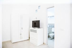 a white bathroom with a tv on a dresser at Urban loft in Forio d'Ischia +31 photos
