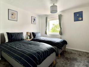 a bedroom with two beds and a window at Cozy 2 bed townhouse close to City Walls in York