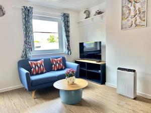 a living room with a blue couch and a table at Cozy 2 bed townhouse close to City Walls in York