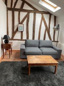 ein Wohnzimmer mit einem blauen Sofa und einem Tisch in der Unterkunft La chambre de Baucis in Tours