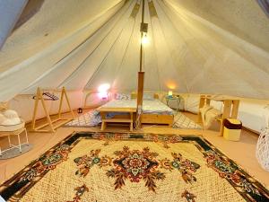 une chambre avec un lit et un tapis dans une tente dans l'établissement Glamping Agapia Agapescu, à Agapia