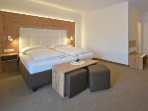 a bedroom with a large bed and a table at Hotel Berghof in Millstatt