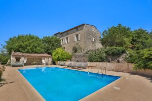 a large swimming pool in front of a building at Chambre d'hôtes Les Temps Heureux in Callian