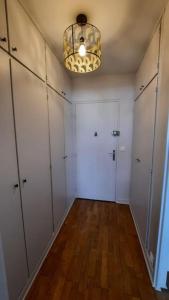 une pièce avec un couloir avec des armoires blanches et un lustre dans l'établissement Appartement 2 pièces tres lumineux, à La Garenne-Colombes