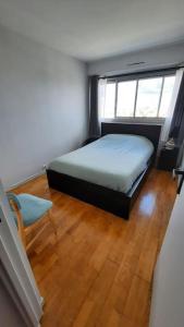 une petite chambre avec un lit et une fenêtre dans l'établissement Appartement 2 pièces tres lumineux, à La Garenne-Colombes