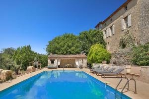 a swimming pool with lounge chairs next to a building at Chambre d'hôtes Les Temps Heureux in Callian