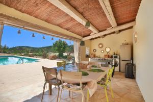 a dining room with a table and chairs and a pool at Chambre d'hôtes Les Temps Heureux in Callian