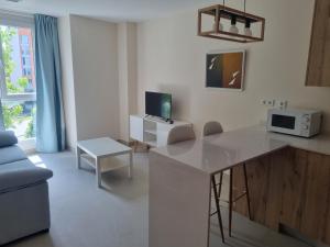 a kitchen and living room with a table and a microwave at ASTURES Viviendas Turísticas in Oviedo