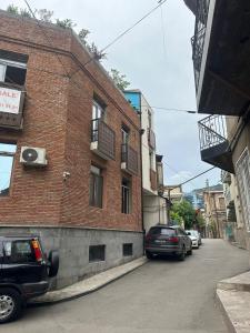 due auto parcheggiate in una strada accanto a un edificio di mattoni di Corner in old Tbilisi a Tbilisi City