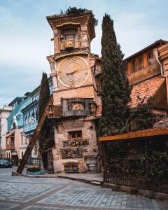 Un palazzo alto con una torre dell'orologio su una strada di Corner in old Tbilisi a Tbilisi City