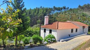 a small white house with a red roof at Casa da Milharica in Figueiró dos Vinhos