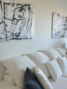 a white couch with pillows and a painting on the wall at Artist Home in Porto Rafti