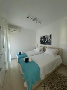 a bedroom with a large white bed with blue blankets at Artist Home in Porto Rafti +22 photos