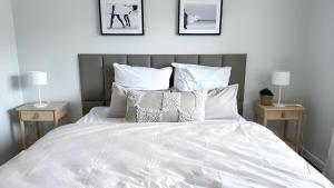 a bedroom with a white bed with two night stands at Business & Leisure Apartment in Ingolstadt +21 photos