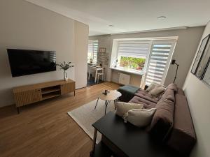 a living room with a brown couch and a table at Suite Dreams in Kėdainiai