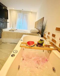 a bathroom with a bathtub with a bowl of water and a bed at Studio Love Jacuzzi in Marseille +11 photos