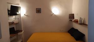 ein kleines Zimmer mit einem Bett und einem Fernseher in der Unterkunft Little House in Káto Petálion