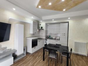 a kitchen with a table and a stove and a counter at Robert's Sweet Station House A in Anguillara Sabazia