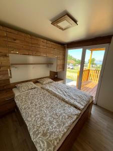 a bedroom with a large bed and a balcony at MIMOSA Luxury Mobile Homes in Sveti Juraj