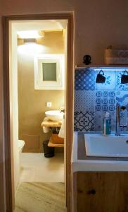 ein Badezimmer mit Waschbecken und Toilette in einem Zimmer in der Unterkunft Little House in Káto Petálion + 28 Fotos
