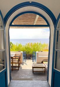 an open door to a patio with tables and benches at La Mia Valigia a Stromboli in Stromboli