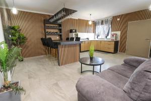 Ramaにあるוילה קריסטל - וילות מדהימות עם בריכות פרטיות, ג'קוזי וסאונהのソファとキッチンのあるリビングルーム