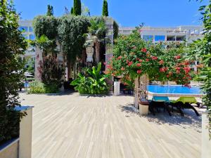 a courtyard with flowers and tables and benches at Argisht STUDIO 602 in Golden Sands