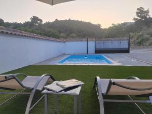 a patio with two chairs and a swimming pool at La Noguera Casa Rural in Huéscar