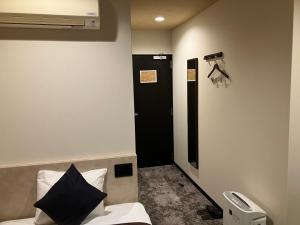 Postel nebo postele na pokoji v ubytování HOTEL LiVEMAX BUDGET Amagasaki