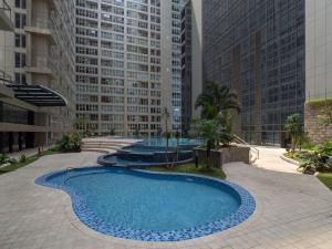 a large swimming pool in a city with tall buildings at 2 BR Apartment Grand Jati Junction Medan view City 12th Floor in Medan