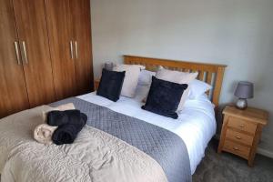 a bedroom with a large bed with two pillows at Windsor property near Legoland with free parking in Windsor