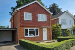 a red brick house with a white garage at Windsor property near Legoland with free parking in Windsor